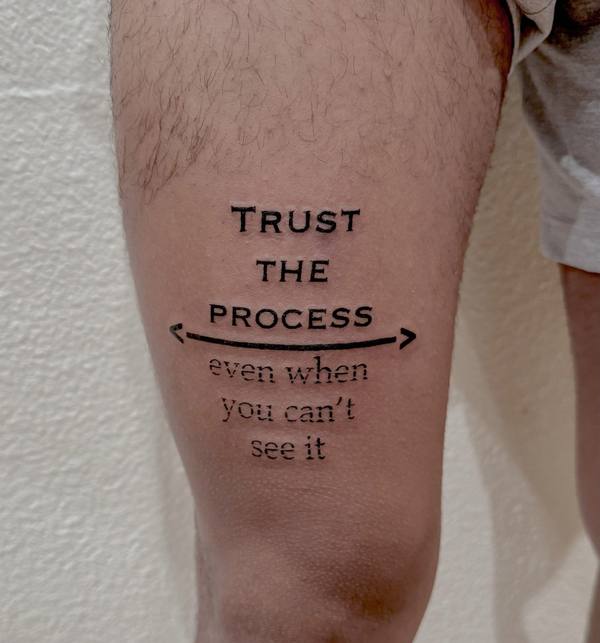 Script lettering “Trust the Process” tattoo by Cihan Pohrenk in Venice, Los Angeles