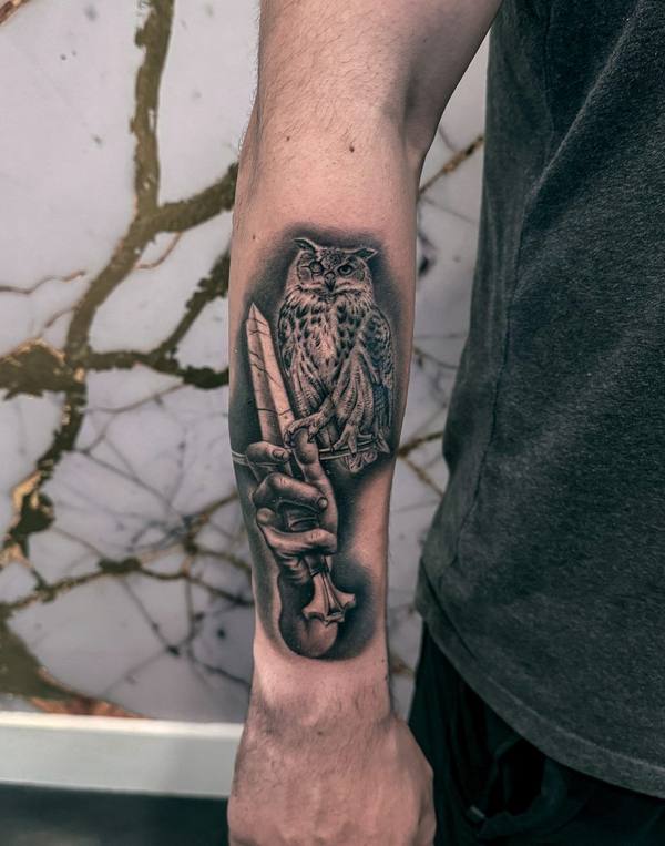 Black and gray realism owl and dagger tattoo by Cihan Pohrenk in Venice, Los Angeles