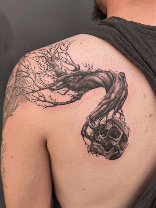 Black and gray realism tree and skull shoulder tattoo by Cihan Pohrenk in Venice, Los Angeles