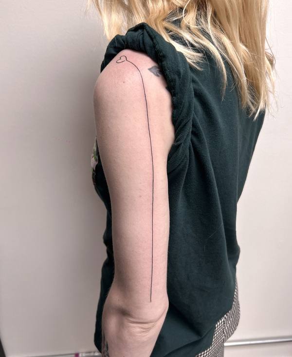 Minimalist heart and single line arm tattoo by Cihan Pohrenk in Venice, Los Angeles