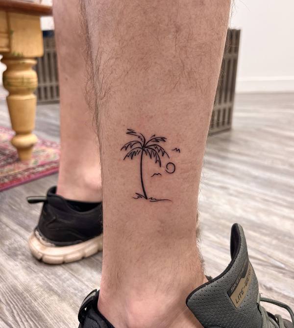 Palm tree and sunset fine line ankle tattoo by Cihan Pohrenk in Venice, Los Angeles