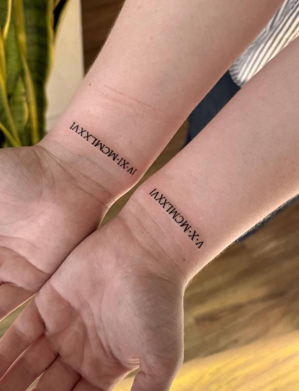 Matching roman numeral date fine line wrist tattoos by Cihan Pohrenk in Venice, Los Angeles