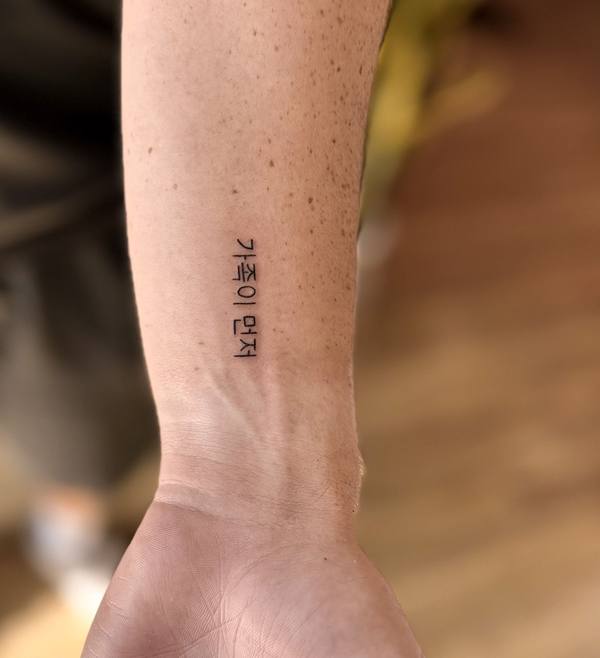 Korean script fine line wrist tattoo by Cihan Pohrenk in Venice, Los Angeles