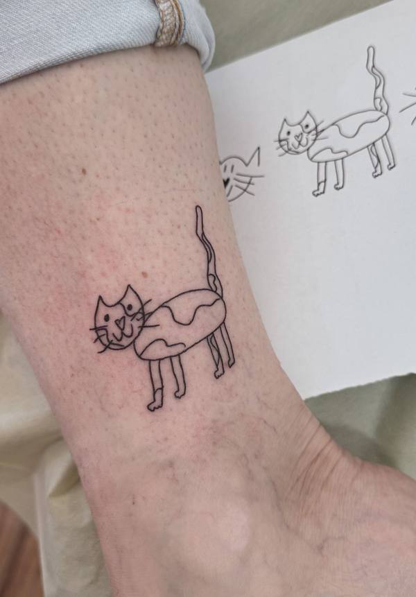 Child's drawing style cat fine line ankle tattoo by Cihan Pohrenk in Venice, Los Angeles